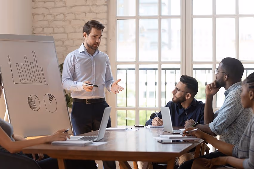 Team collaborating around a table reviewing performance information